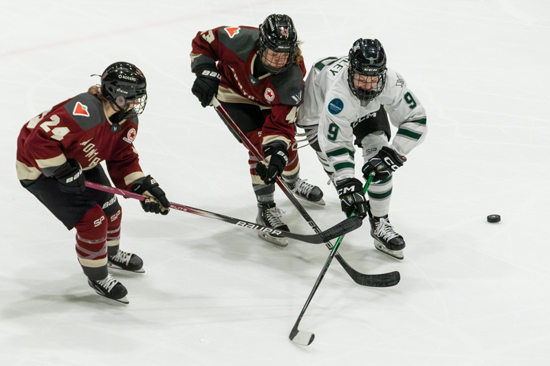 Montreal's Ann-Sophie Bettez watches as Kristin O'Neill and Sophie Shirley battle for the puck. | photo: Kieron Yates / Modern Free Press
